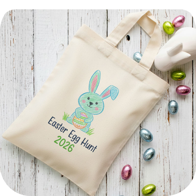 A tote bag with a child like colouring of an Easter Bunny and the text "Easter Egg Hunt 2026" under it